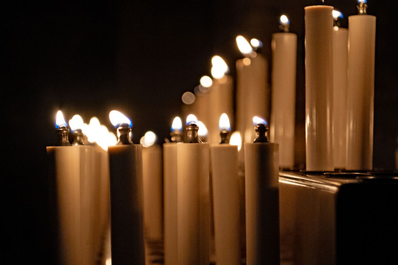 A serene display of burning candles inside a dimly lit cathedral in Regensburg, Germany.